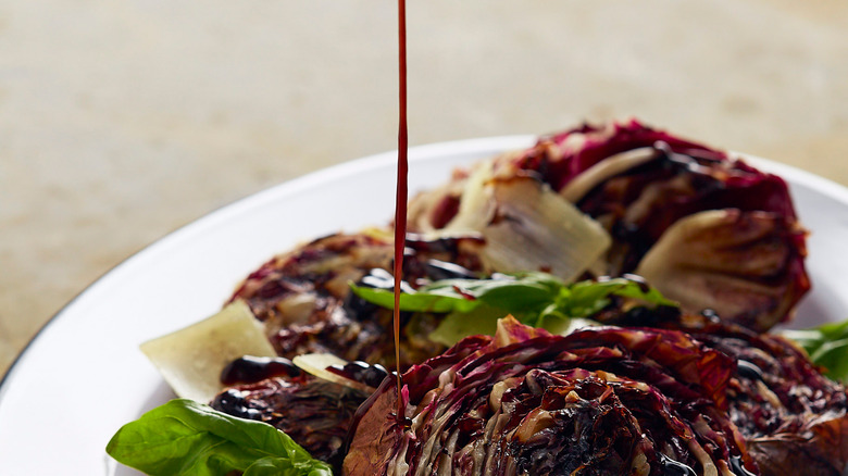 Pouring balsamic glaze on plate 