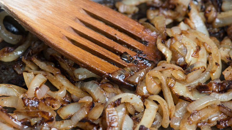 stirring caramelized onions with wooden spatula