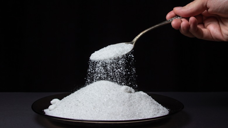 hand pouring salt with spoon