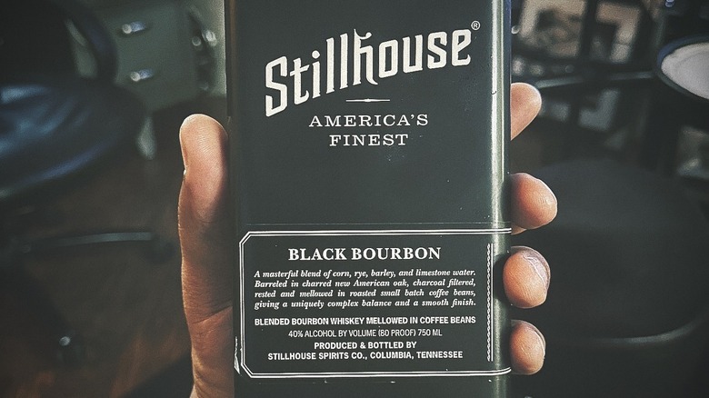 Hand holding bottle of Stillhouse bourbon