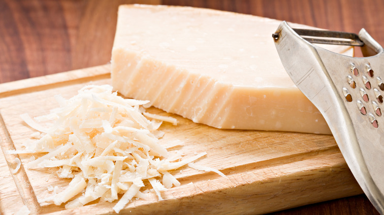 Partially grated Parmesan cheese on cutting board