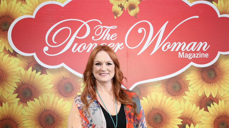 Ree Drummond smiling in front of Pioneer Woman sign