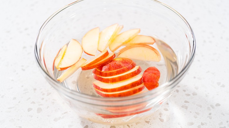 apple slices in bowl of water