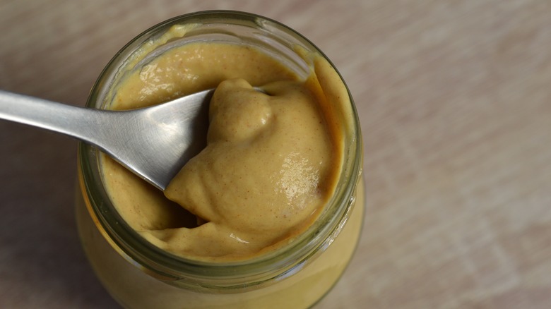 spoon in jar of Dijon mustard