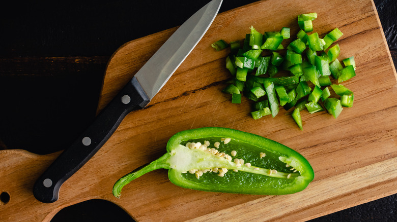 dicing fresh jalapeño on cutting board