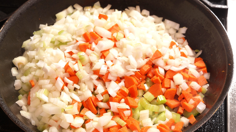 celery, carrot and onion cooking in skillet