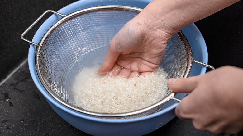 woman rinsing grains with colander