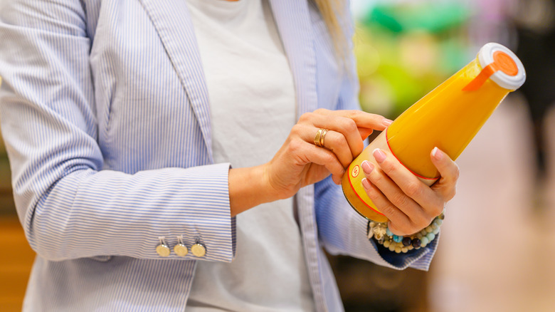 Woman reading juice bottle label