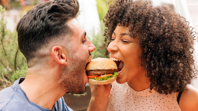 couple sharing hamburger