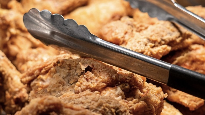 Closeup of fried chicken with tongs