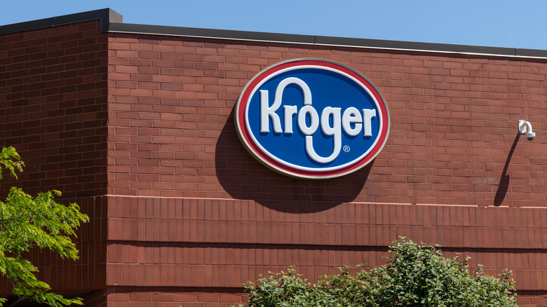 Round, blue Kroger logo on brick building