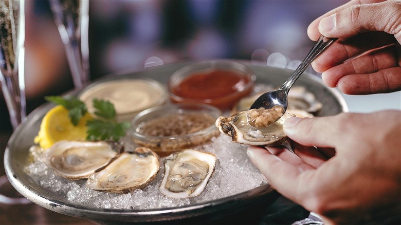 Person enjoying raw oysters