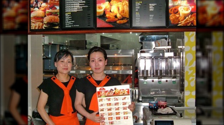 ladies displaying Samtaesong menu in North Korea