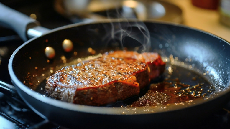 steak frying in pan