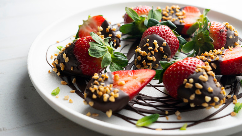 Chocolate-coated strawberry rolled in nuts