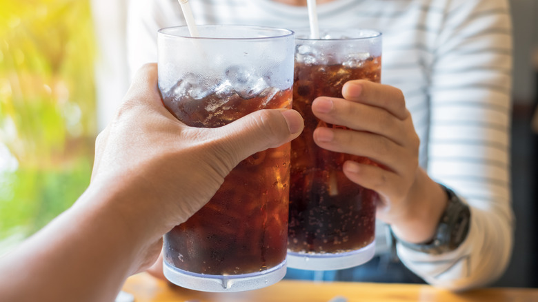 People holding cups of soda