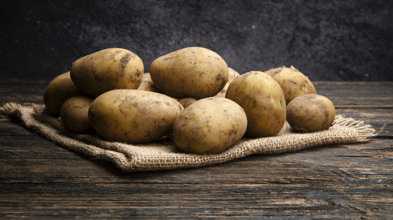 Potatoes on a cloth on a wooden table