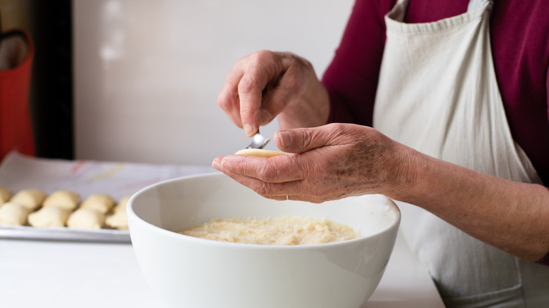 Woman filling pierogi with potatoes