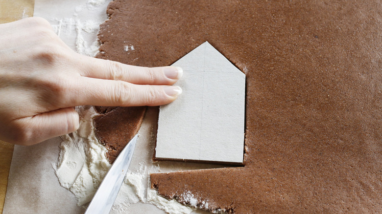 Person using template for gingerbread house