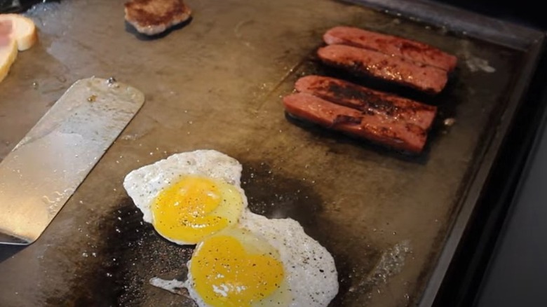 Split sausages on griddle