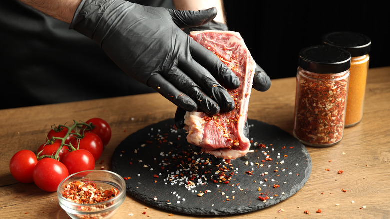 applying a spice rub on steak