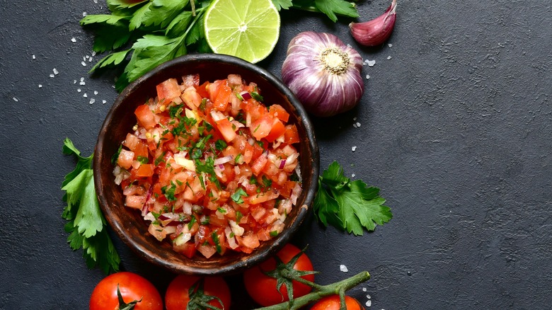 Bowl of fresh salsa and its ingredients