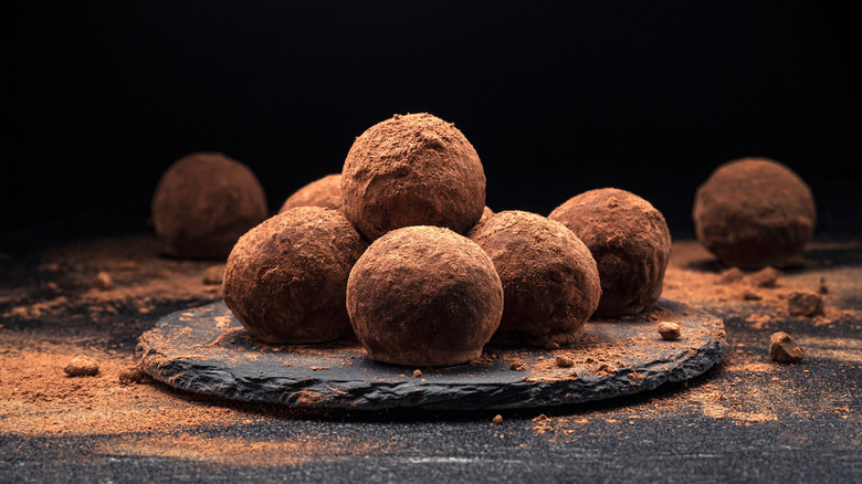 Chocolate truffles on a black plate