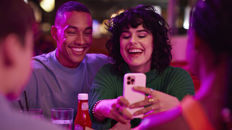 woman taking video at bar