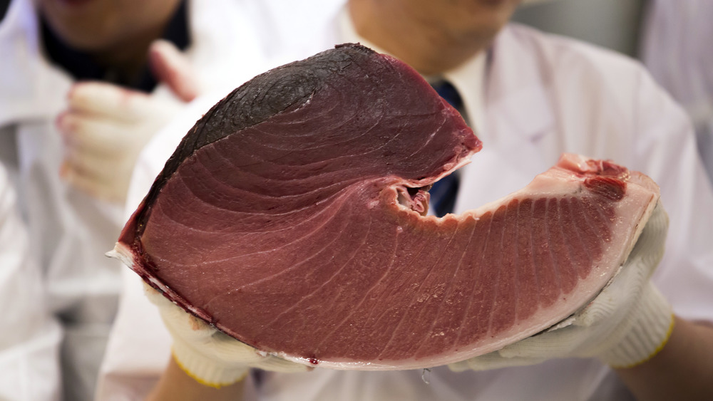 man holding a bluefin tuna steak