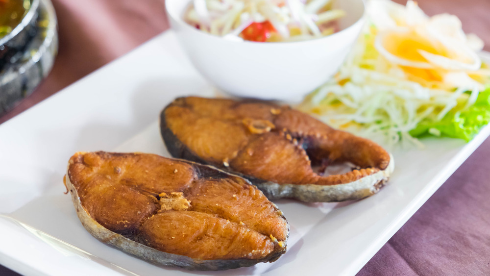 fried king mackerel on plate with salad