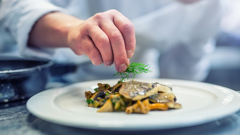 chef garnishing a fish steak