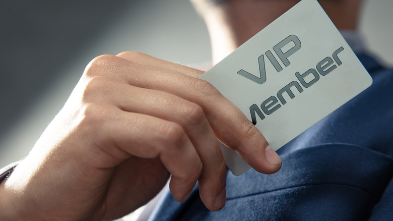 man holding VIP membership card