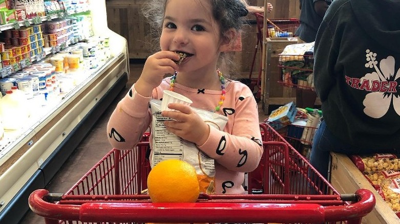 toddler enjoying free sample in cart 