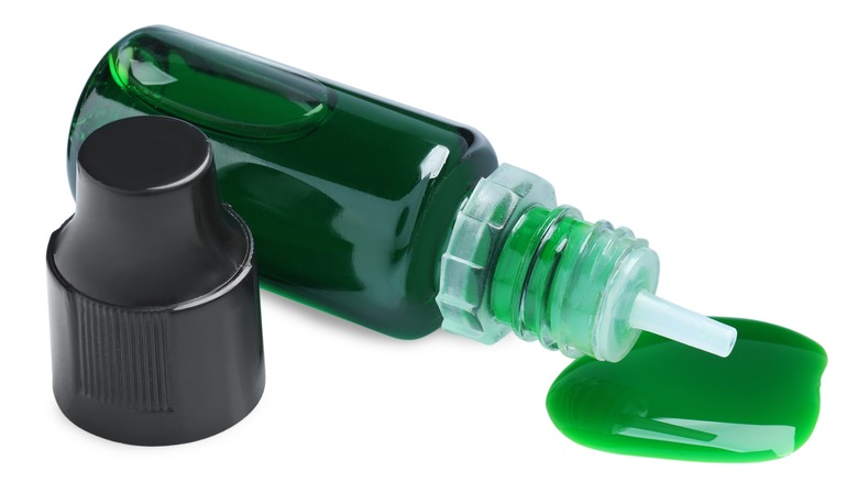 bottle of green food coloring spilling