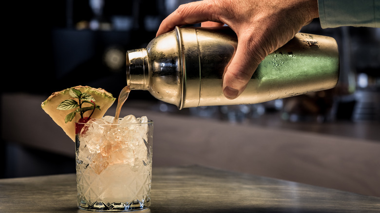 A mocktail being poured from a shaker