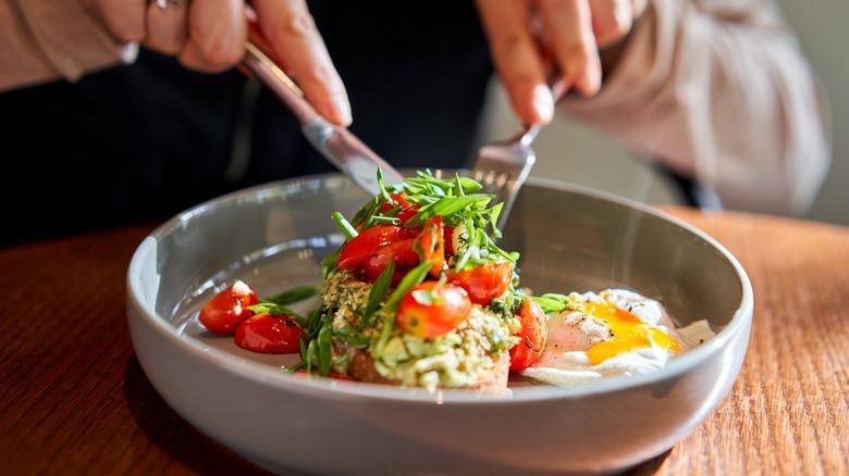 Eggs Benedict with tomatoes and herbs