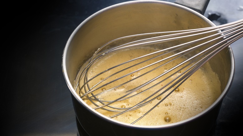 Hollandaise in a pot with a whisk