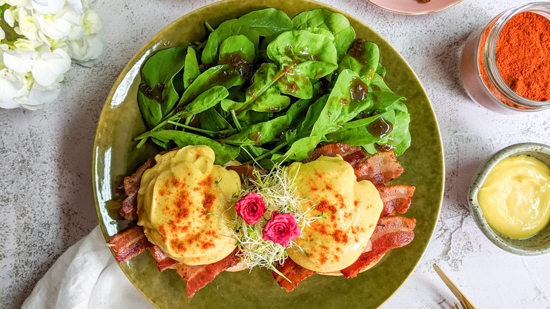 Eggs Benedict with cayenne pepper seasoning and fresh salad