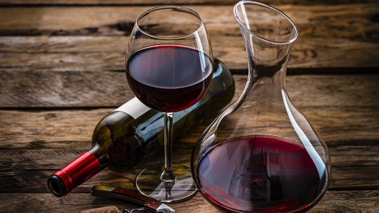 Glass, decanter, and bottle of red wine on table