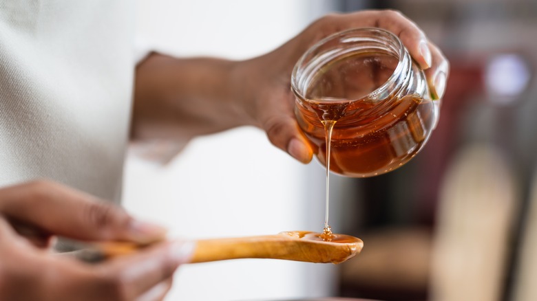 Pouring honey onto spoon