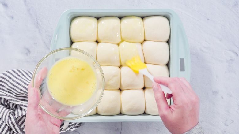 Brushing butter on unbaked rolls