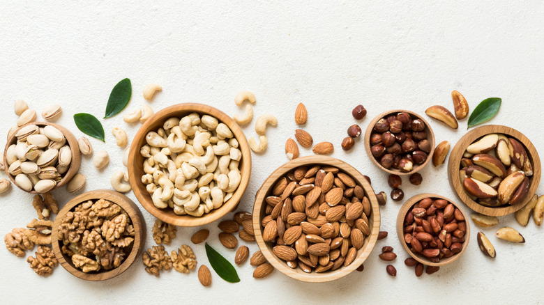 Several bowls of nuts on a white background