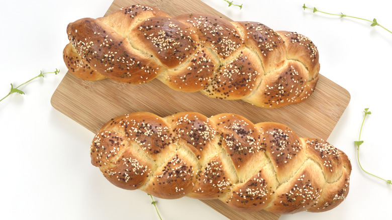 Two loaves of challah on a wood board