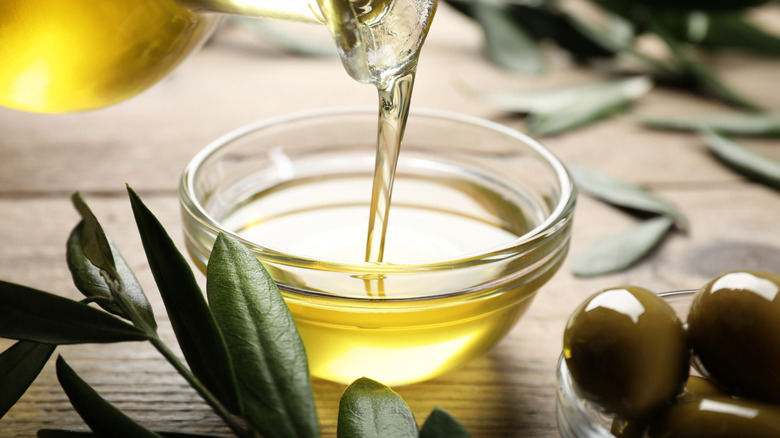 olive oil pouring into glass bowl