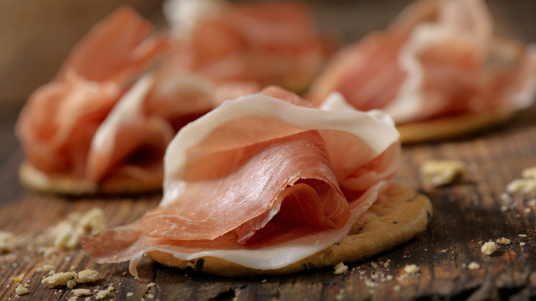 thinly sliced prosciutto on cracker