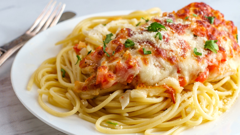 plate of cheesy chicken parm on spaghetti