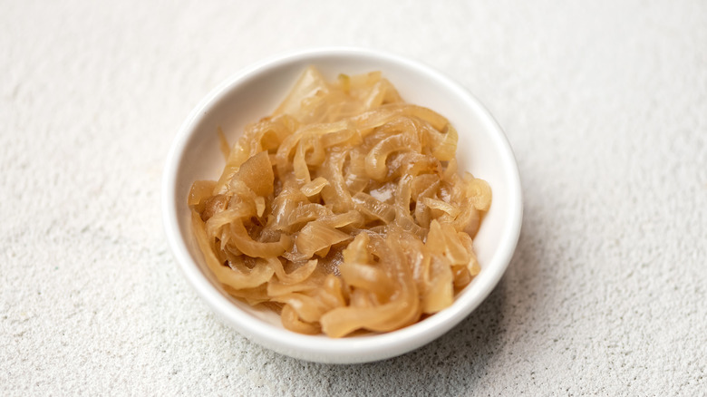 A white bowl filled with caramelized onions