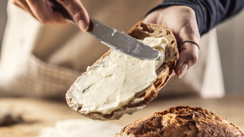 woman spreading cheese spread on bread