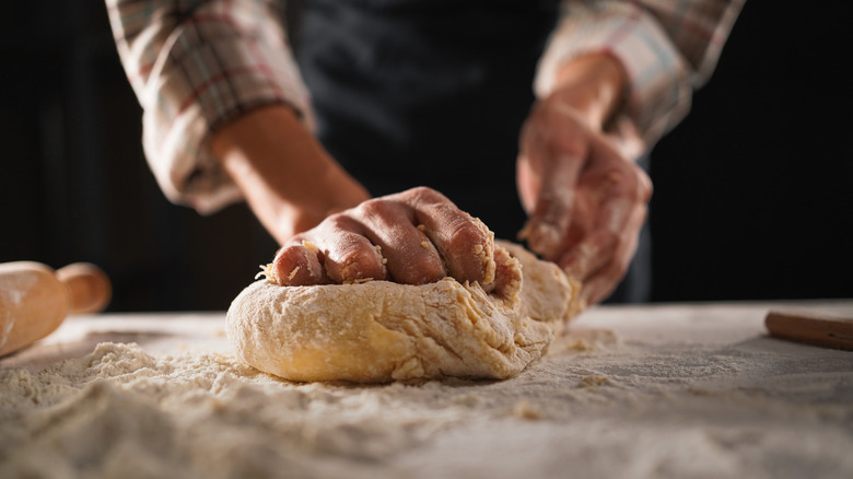 hands kneading dough for bread