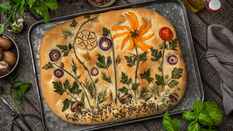 focaccia with artistic vegetable and herb design